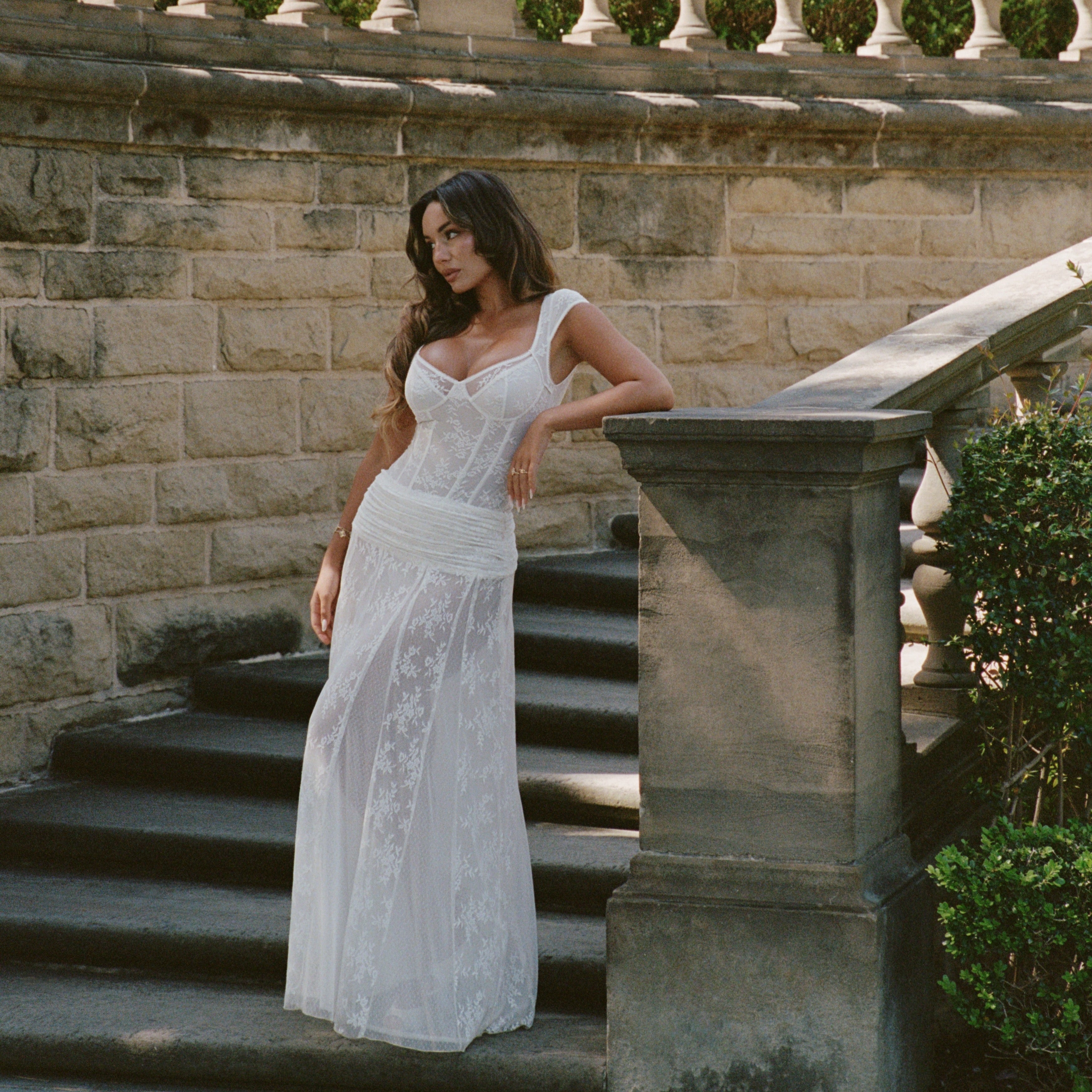 a woman in a white dress posing for a picture