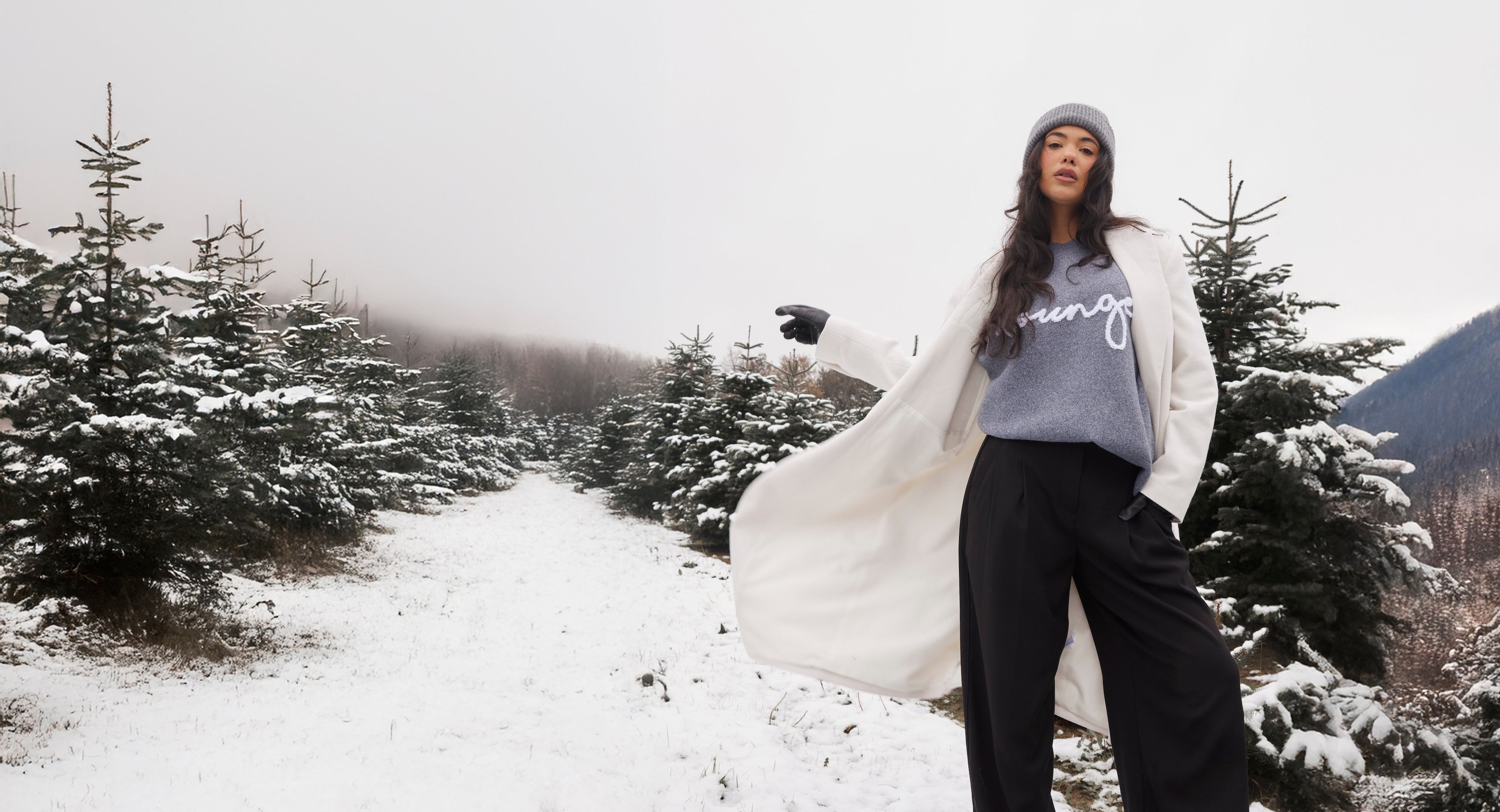 a woman pointing at something in the snow