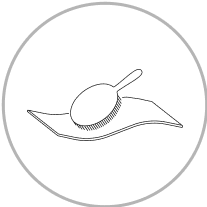a black and white circular object with a brush on a white surface