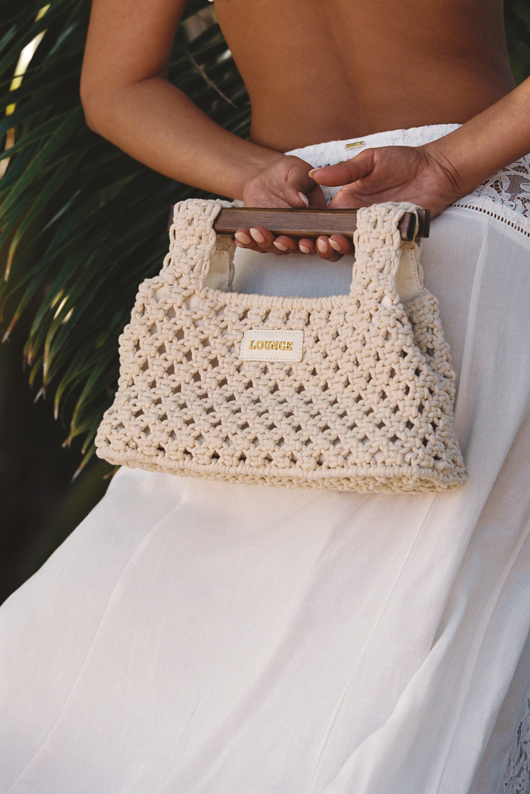 a woman holding a crochet bag